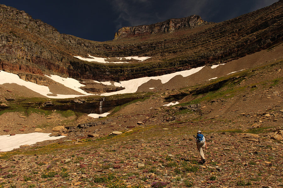 Look for faint trails in the scree leading to a break in the cliffs on the right.